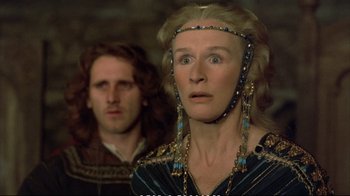 Movie still from “Hamlet” (1990), directed by Franco Zeffirelli – A woman in a blue and black dress and a man in a black and white shirt; Close Up shot, Over the shoulder angle