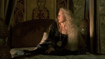 Movie still from “Hamlet” (1990), directed by Franco Zeffirelli – A woman sitting on top of a bed in a dark room; Medium shot, Low angle