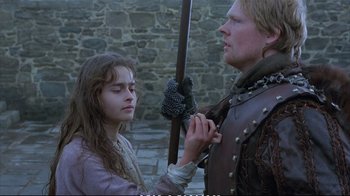 Movie still from “Hamlet” (1990), directed by Franco Zeffirelli – A man and a woman in medieval garb holding a sword; Medium shot, Over the shoulder angle