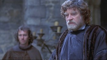 Movie still from “Hamlet” (1990), directed by Franco Zeffirelli – A man with long hair and a beard standing next to another man with long hair; Close Up shot, Over the shoulder angle