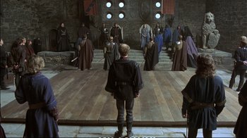 Movie still from “Hamlet” (1990), directed by Franco Zeffirelli – A group of people dressed in medieval garb in a building; Wide shot, High angle