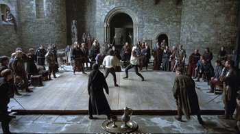 Movie still from “Hamlet” (1990), directed by Franco Zeffirelli – A group of people in medieval garb playing a game of sword fighting; Wide shot, High angle