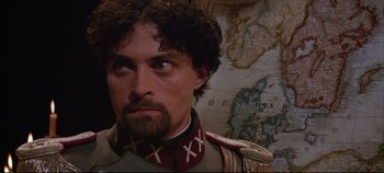 Movie still from “Hamlet” (1996), directed by Kenneth Branagh – A person with a map in the background; Close Up shot, Low angle