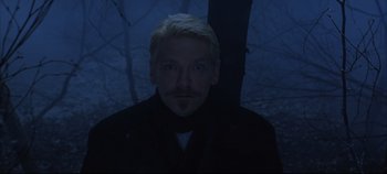 Movie still from “Hamlet” (1996), directed by Kenneth Branagh – A man with a beard and mustache wearing a black jacket; Medium shot, Over the shoulder angle