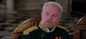Movie still from “Hamlet” (1996), directed by Kenneth Branagh – An older man with a beard wearing a military uniform; Close Up shot, Over the shoulder angle