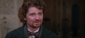 Movie still from “Hamlet” (1996), directed by Kenneth Branagh – A person wearing a suit and tie; Close Up shot, Over the shoulder angle
