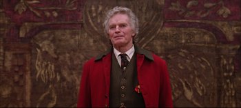 Movie still from “Hamlet” (1996), directed by Kenneth Branagh – An older man wearing a suit and a tie; Medium shot, Low angle