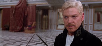 Movie still from “Hamlet” (1996), directed by Kenneth Branagh – A person wearing a suit and tie; Close Up shot, Over the shoulder angle
