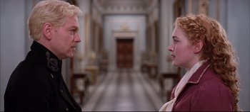 Movie still from “Hamlet” (1996), directed by Kenneth Branagh – A man and a woman standing in front of each other in a hallway; Medium shot, Over the shoulder angle