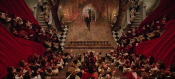 Movie still from “Hamlet” (1996), directed by Kenneth Branagh – A large group of people sitting in a room; Extreme Wide shot, High angle