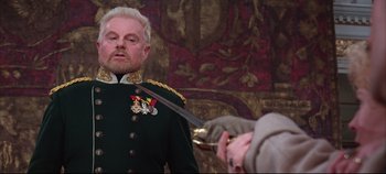 Movie still from “Hamlet” (1996), directed by Kenneth Branagh – A man in a military uniform is holding a sword; Close Up shot, Over the shoulder angle