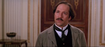 Movie still from “Hamlet” (1996), directed by Kenneth Branagh – A person wearing a suit and tie; Close Up shot, Low angle