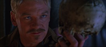 Movie still from “Hamlet” (1996), directed by Kenneth Branagh – A person holding a skull; Close Up shot, Over the shoulder angle