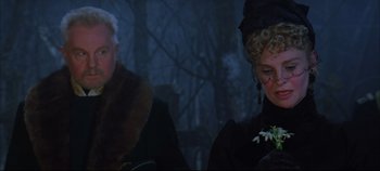 Movie still from “Hamlet” (1996), directed by Kenneth Branagh – A man and a woman sitting next to each other in front of trees; Close Up shot, Over the shoulder angle