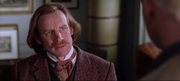 Movie still from “Hamlet” (1996), directed by Kenneth Branagh – A person wearing a suit and tie; Close Up shot, Over the shoulder angle