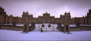 Movie still from “Hamlet” (1996), directed by Kenneth Branagh – A person walking in the snow near a large gate; Extreme Wide shot, High angle