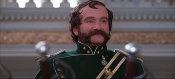 Movie still from “Hamlet” (1996), directed by Kenneth Branagh – Robin williams in a green military uniform with a mustache; Close Up shot, Low angle