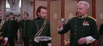 Movie still from “Hamlet” (1996), directed by Kenneth Branagh – A man in a green uniform holding a silver goblet; Medium shot, Low angle