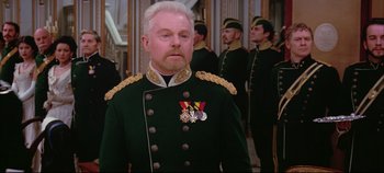 Movie still from “Hamlet” (1996), directed by Kenneth Branagh – A man in a military uniform standing in front of a group of men; Medium shot, Over the shoulder angle