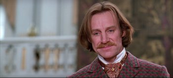 Movie still from “Hamlet” (1996), directed by Kenneth Branagh – A person wearing a suit and tie; Close Up shot, Low angle