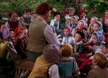 Movie still from “Hans Christian Andersen” (1952), directed by Charles Vidor – A group of children sitting in a circle with an older man; Wide shot, High angle