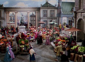 Movie still from “Hans Christian Andersen” (1952), directed by Charles Vidor – A painting of a street market with people selling fruits and vegetables; Extreme Wide shot, High angle