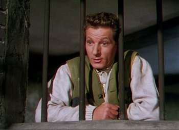 Movie still from “Hans Christian Andersen” (1952), directed by Charles Vidor – A man sitting behind bars in a jail cell; Medium shot, Low angle