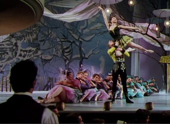 Movie still from “Hans Christian Andersen” (1952), directed by Charles Vidor – A group of people sitting and standing on a stage; Wide shot, Low angle