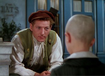 Movie still from “Hans Christian Andersen” (1952), directed by Charles Vidor – A man wearing a hat is talking to another man; Medium shot, Over the shoulder angle