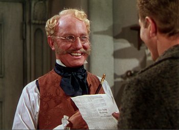 Movie still from “Hans Christian Andersen” (1952), directed by Charles Vidor – An old man with a beard and mustache is holding a piece of paper; Close Up shot, Over the shoulder angle