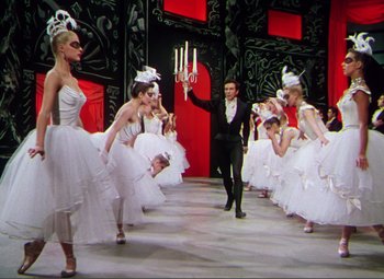 Movie still from “Hans Christian Andersen” (1952), directed by Charles Vidor – A group of young ballerinas are dancing in front of a man; Wide shot, Low angle