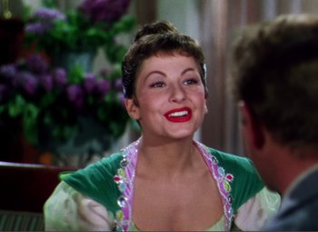 Movie still from “Hans Christian Andersen” (1952), directed by Charles Vidor – A woman in a green and white dress smiling; Close Up shot, Over the shoulder angle