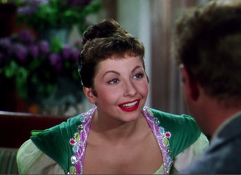 Movie still from “Hans Christian Andersen” (1952), directed by Charles Vidor – A woman with red lipstick smiles at the camera; Close Up shot, Over the shoulder angle