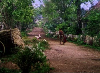Movie still from “Hans Christian Andersen” (1952), directed by Charles Vidor – A man walking down a dirt road near a forest; Wide shot, High angle