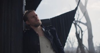 Movie still from “True History of the Kelly Gang” (2019), directed by Justin Kurzel – A man with a beard is standing outside looking up; Close Up shot, Low angle
