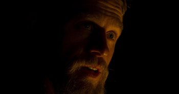 Movie still from “True History of the Kelly Gang” (2019), directed by Justin Kurzel – A man with a long beard is looking at the camera; Close Up shot, High angle