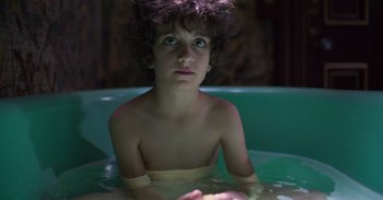 Movie still from “True History of the Kelly Gang” (2019), directed by Justin Kurzel – A young boy sitting in a pool of water; Close Up shot, High angle