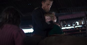 Movie still from “True History of the Kelly Gang” (2019), directed by Justin Kurzel – A man and a woman are hugging in a barn; Medium shot, Over the shoulder angle