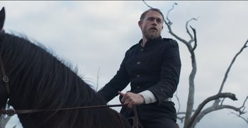Movie still from “True History of the Kelly Gang” (2019), directed by Justin Kurzel – A man riding on the back of a black horse; Medium shot, Low angle