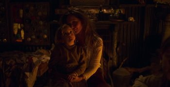 Movie still from “True History of the Kelly Gang” (2019), directed by Justin Kurzel – A woman and a child in a room lit by a lamp; Medium shot, Over the shoulder angle