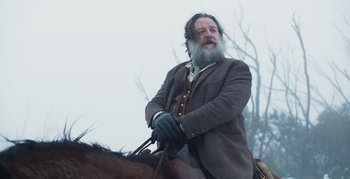 Movie still from “True History of the Kelly Gang” (2019), directed by Justin Kurzel – A man with a long beard riding on a horse; Close Up shot, Low angle