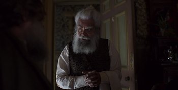 Movie still from “True History of the Kelly Gang” (2019), directed by Justin Kurzel – An old man with a long white beard; Medium shot, Over the shoulder angle