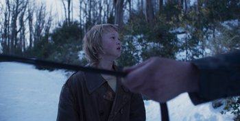 Movie still from “True History of the Kelly Gang” (2019), directed by Justin Kurzel – A young boy holding a wand in the snow; Close Up shot, Over the shoulder angle