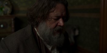 Movie still from “True History of the Kelly Gang” (2019), directed by Justin Kurzel – An older man with a beard and a mustache; Close Up shot, Over the shoulder angle