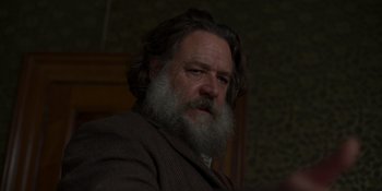 Movie still from “True History of the Kelly Gang” (2019), directed by Justin Kurzel – A man with a long beard is sitting in a chair; Close Up shot, Low angle