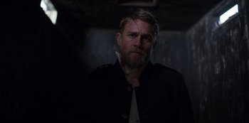 Movie still from “True History of the Kelly Gang” (2019), directed by Justin Kurzel – A man with a beard wearing a black jacket; Close Up shot, Over the shoulder angle