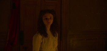 Movie still from “True History of the Kelly Gang” (2019), directed by Justin Kurzel – A young girl standing in front of a wooden door; Medium shot, Over the shoulder angle