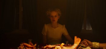 Movie still from “True History of the Kelly Gang” (2019), directed by Justin Kurzel – A woman sitting at a table in a dimly - lit room; Medium shot, Over the shoulder angle