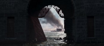 Movie still from “True History of the Kelly Gang” (2019), directed by Justin Kurzel – Smoke billows out of a fire that is burning in the ocean; Extreme Wide shot, Low angle
