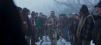 Movie still from “True History of the Kelly Gang” (2019), directed by Justin Kurzel – A group of people standing around a man in a blanket; Wide shot, Low angle